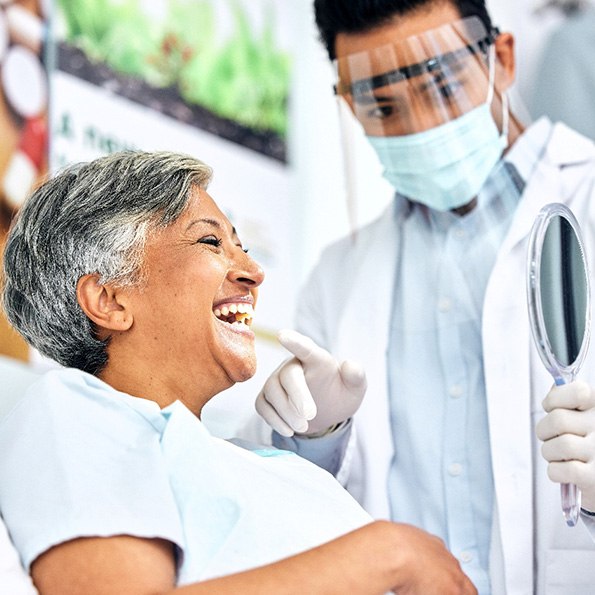 Dentist showing patient smiling in reflection