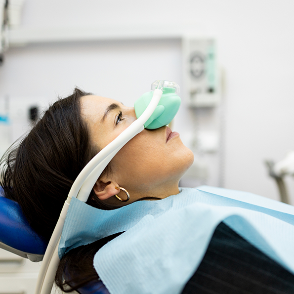 Woman in dental chair with nitrous oxide mask over her nose