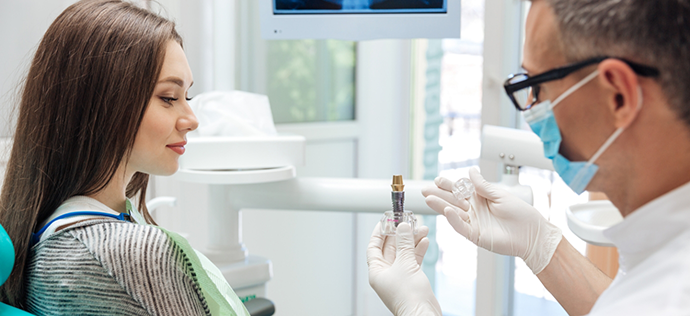 Dentist showing a dental implant in Warrenton to a patient