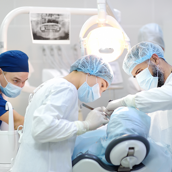 Group of dental professionals performing dental implant surgery