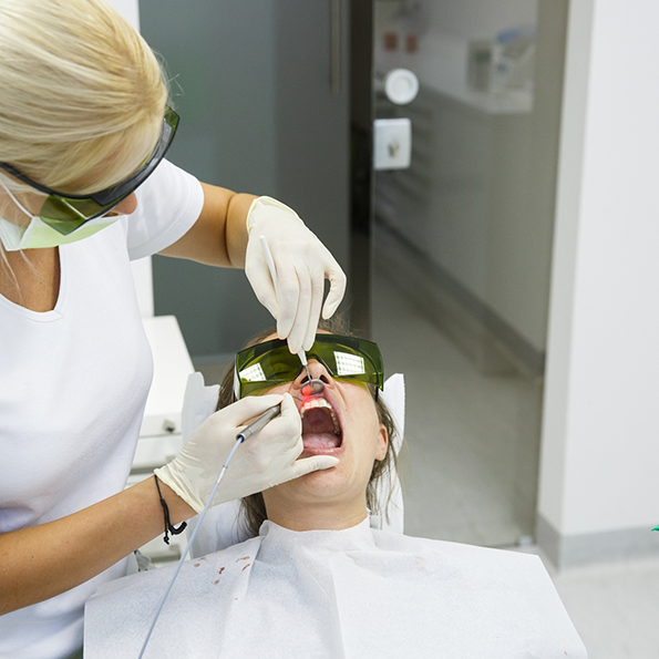 Dentist treating a patients gums with a soft tissue laser