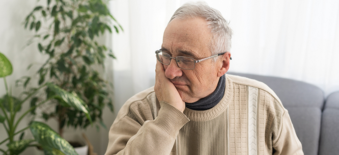 Older man holding his jaw in pain needing emergency dentist in Warrenton