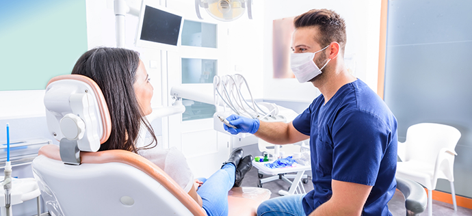 Woman in dental chair talking to her dentist in Warrenton