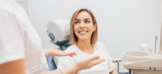 Woman in dental chair talking to her dentist in Warrenton