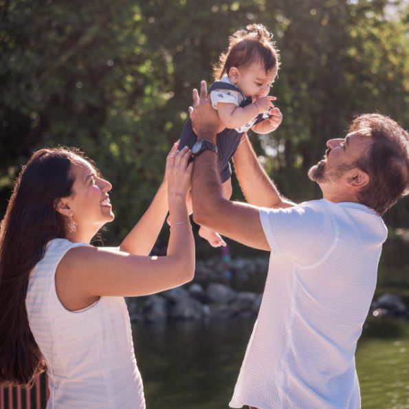 Doctor Nayak and his wife holding their young son outdoors