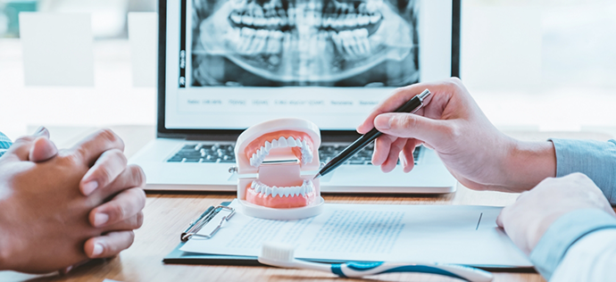 Patient sitting across desk from their dentist during a consultation