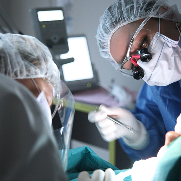 Two dentists performing a dental procedure on a patient