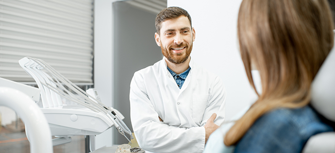 Woman talking to her dentist before tooth extractions in Warrenton